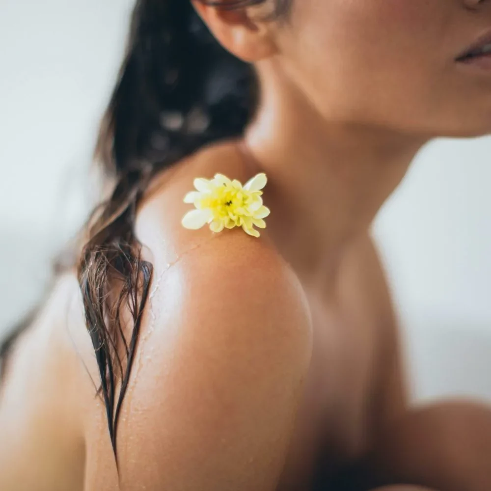Femme en détente avec les cheveux humides et une fleur sur l"épaule, ambiance bien-être et relaxation à Levens
